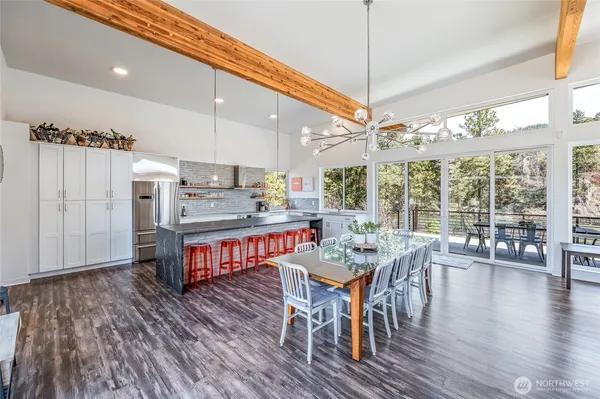 a view of a dining room and livingroom with furniture wooden floor a chandelier
