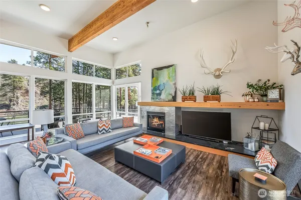 a living room with furniture a flat screen tv and a floor to ceiling window