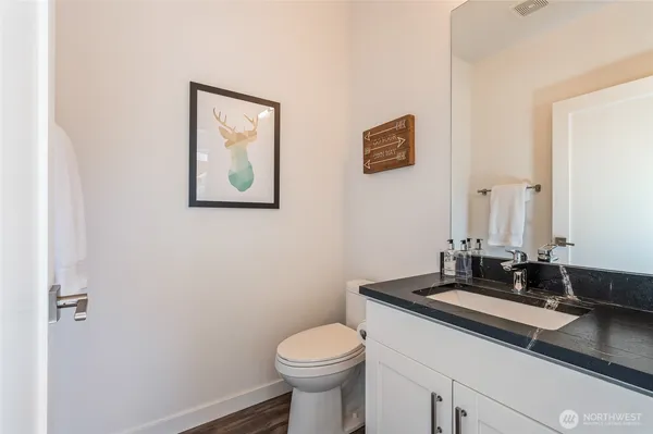 a bathroom with a granite countertop sink mirror and toilet