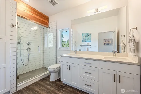 a bathroom with a granite countertop sink a toilet and shower