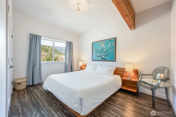 a bedroom with a bed and wooden floor
