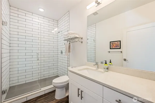 a bathroom with a sink a toilet and shower