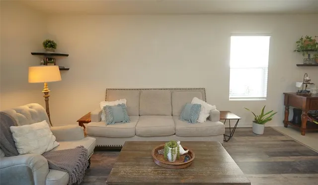 a living room with furniture a rug and a window