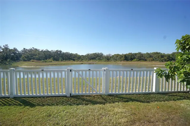 a view of a yard with wooden fence