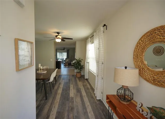 a view of a hallway with furniture and wooden floor