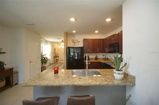 a kitchen with stainless steel appliances granite countertop a sink and a refrigerator