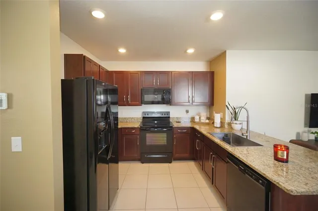 a kitchen with stainless steel appliances granite countertop a refrigerator and a sink