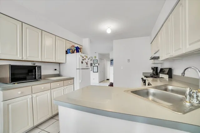 a kitchen with stainless steel appliances a sink a stove and a refrigerator with wooden cabinets