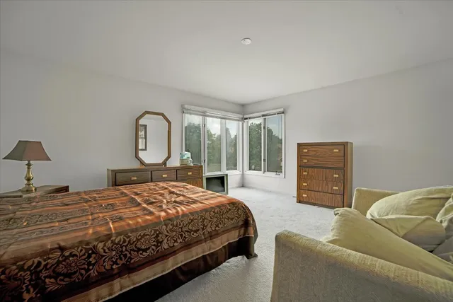 a bedroom with a large bed couch and dresser