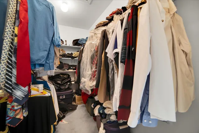 a view of walk in closet with clothes