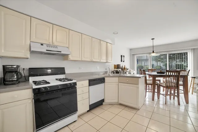 a kitchen with cabinets appliances and a dining table