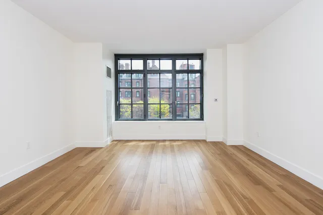 a bedroom with bed couch and window