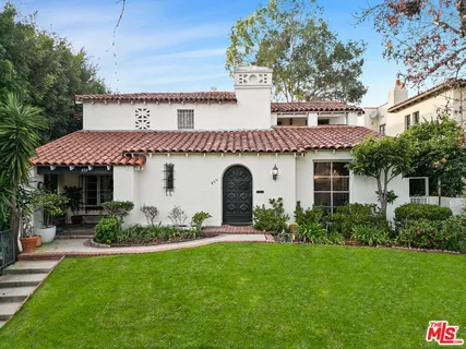 a front view of a house with a garden and plants