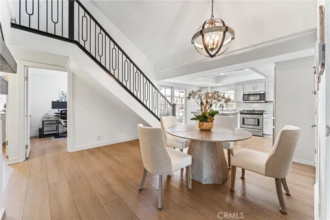 a view of a dining room with furniture a chandelier and wooden floor