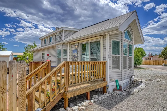 a view of a house with a small yard and wooden fence