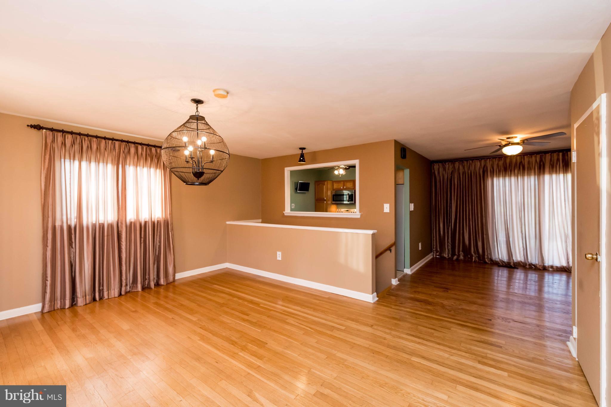 810 Crosby Road Baltimore, MD 21228 - Photo 3 of 30 an empty room with wooden floor and windows