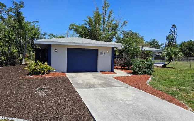 a front view of a house with a yard and a garage