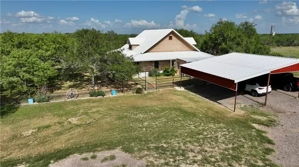 a aerial view of a house with table and chairs under an umbrella