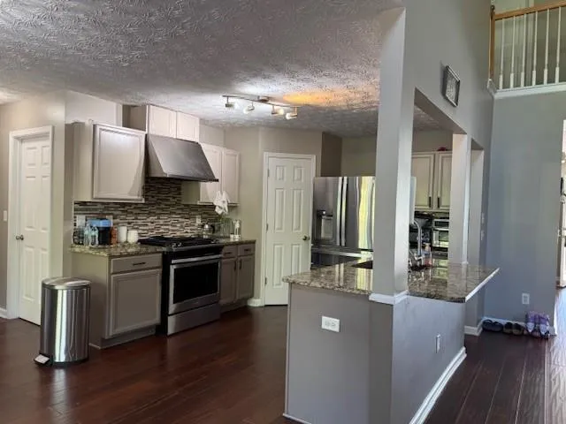 a kitchen with stainless steel appliances a stove a sink and a refrigerator