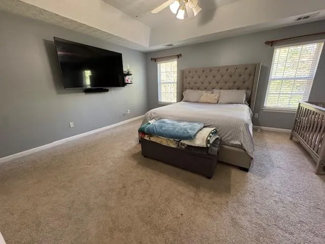 a spacious bedroom with a bed and a flat screen tv