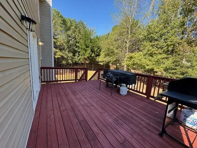 a balcony with wooden floor table and chairs