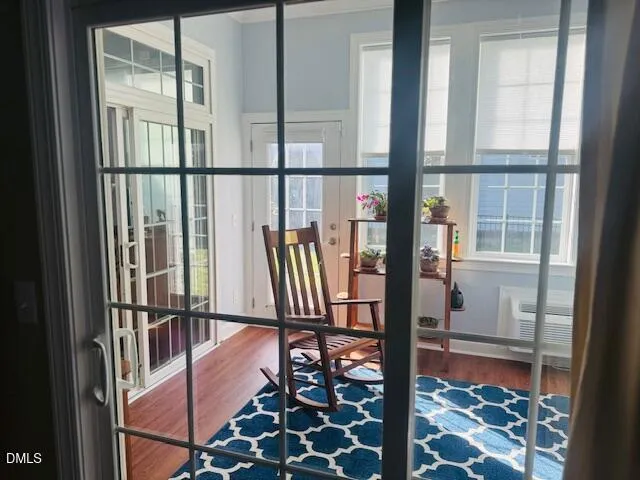 a view of a hallway with wooden floor and windows