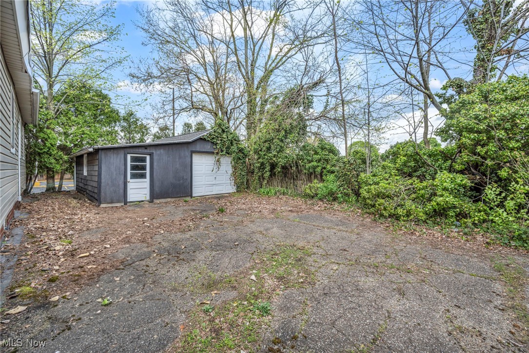 back of home with detached one car garage