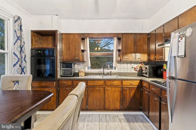 a kitchen with stainless steel appliances granite countertop a sink a stove and a refrigerator