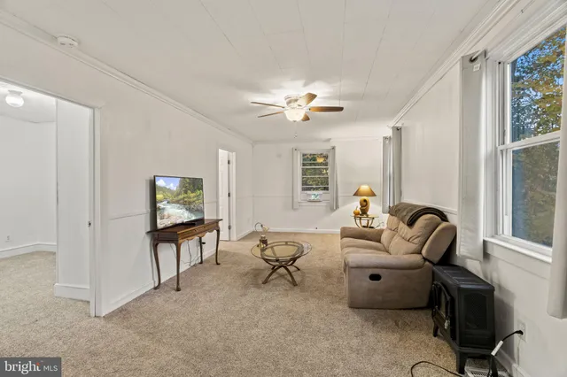 a living room with furniture a ceiling fan and a window