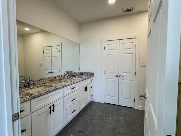 a bathroom with a granite countertop sink and a mirror