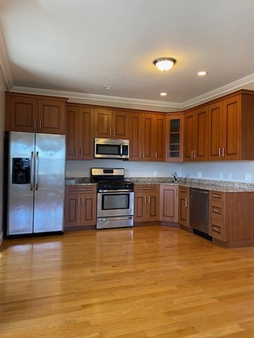 a kitchen with stainless steel appliances wooden cabinets and a counter top space