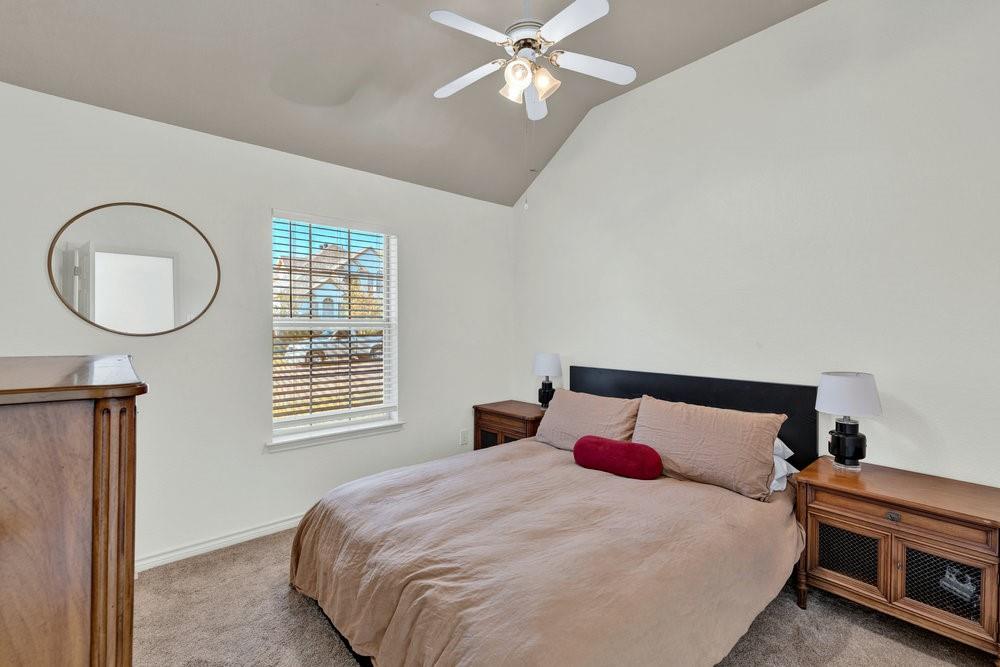 18 Equestrian Court Mansfield, TX 76063 - Photo 16 of 28 a bedroom with a large bed and a chandelier