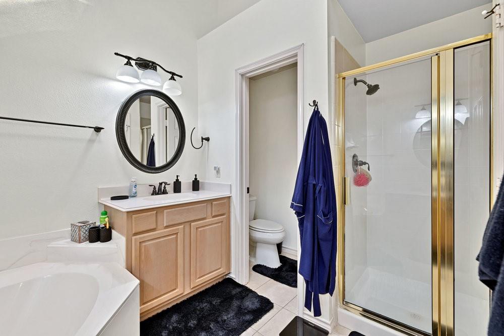 18 Equestrian Court Mansfield, TX 76063 - Photo 20 of 28 a bathroom with a sink a mirror and a shower