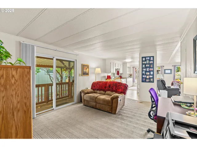 a living room with furniture a flat screen tv and a floor to ceiling window