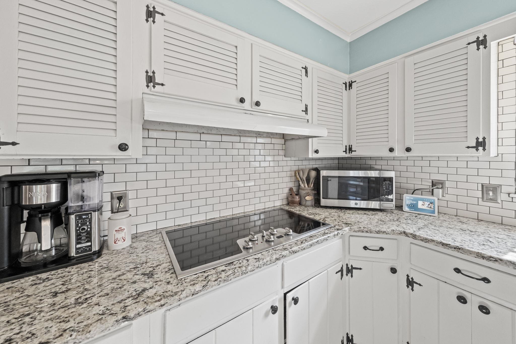 446 Rosser Road Memphis, TN 38120 - Photo 13 of 30 a kitchen with granite countertop a stove a sink and a microwave