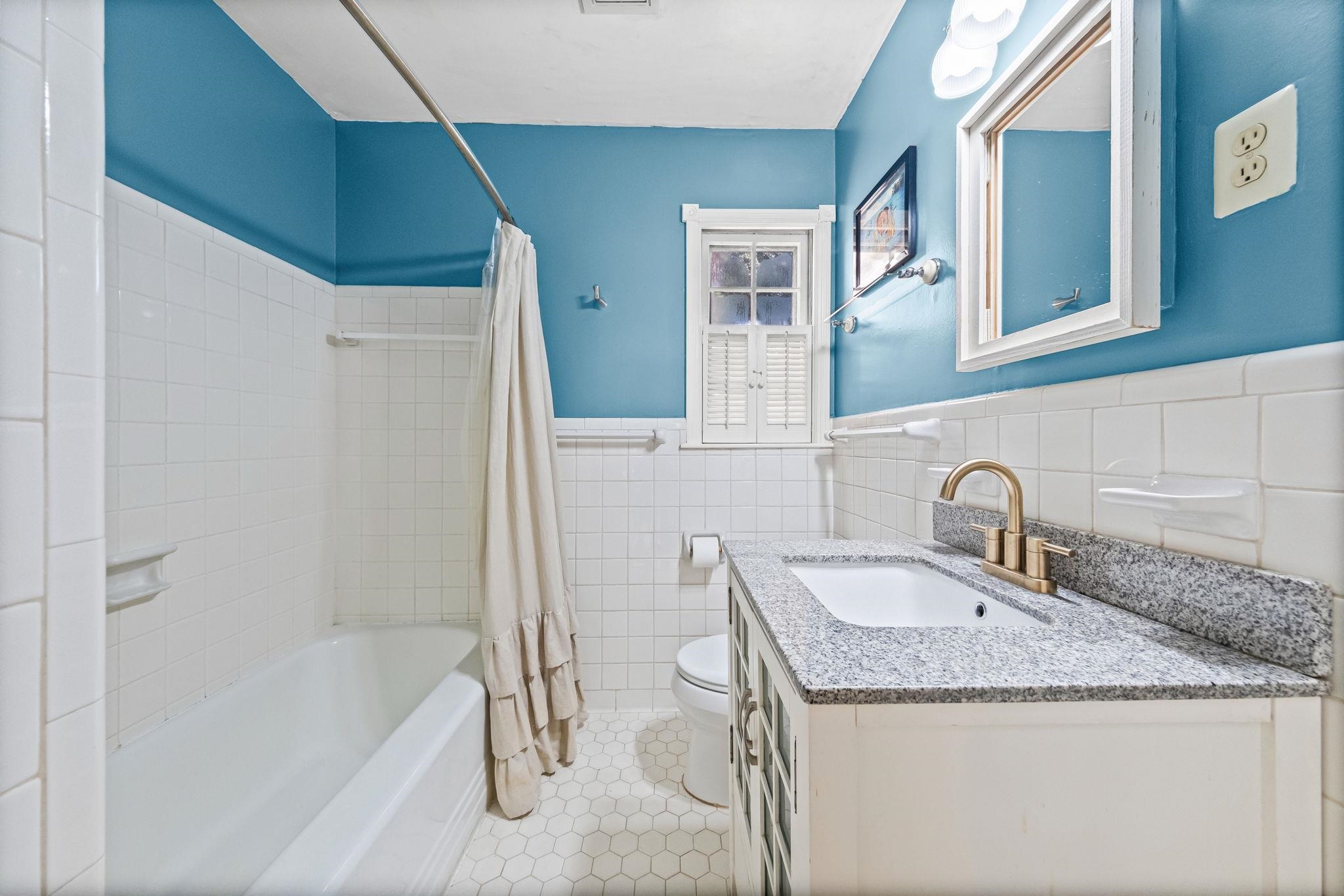 446 Rosser Road Memphis, TN 38120 - Photo 24 of 30 a bathroom with a granite countertop sink and a bathtub