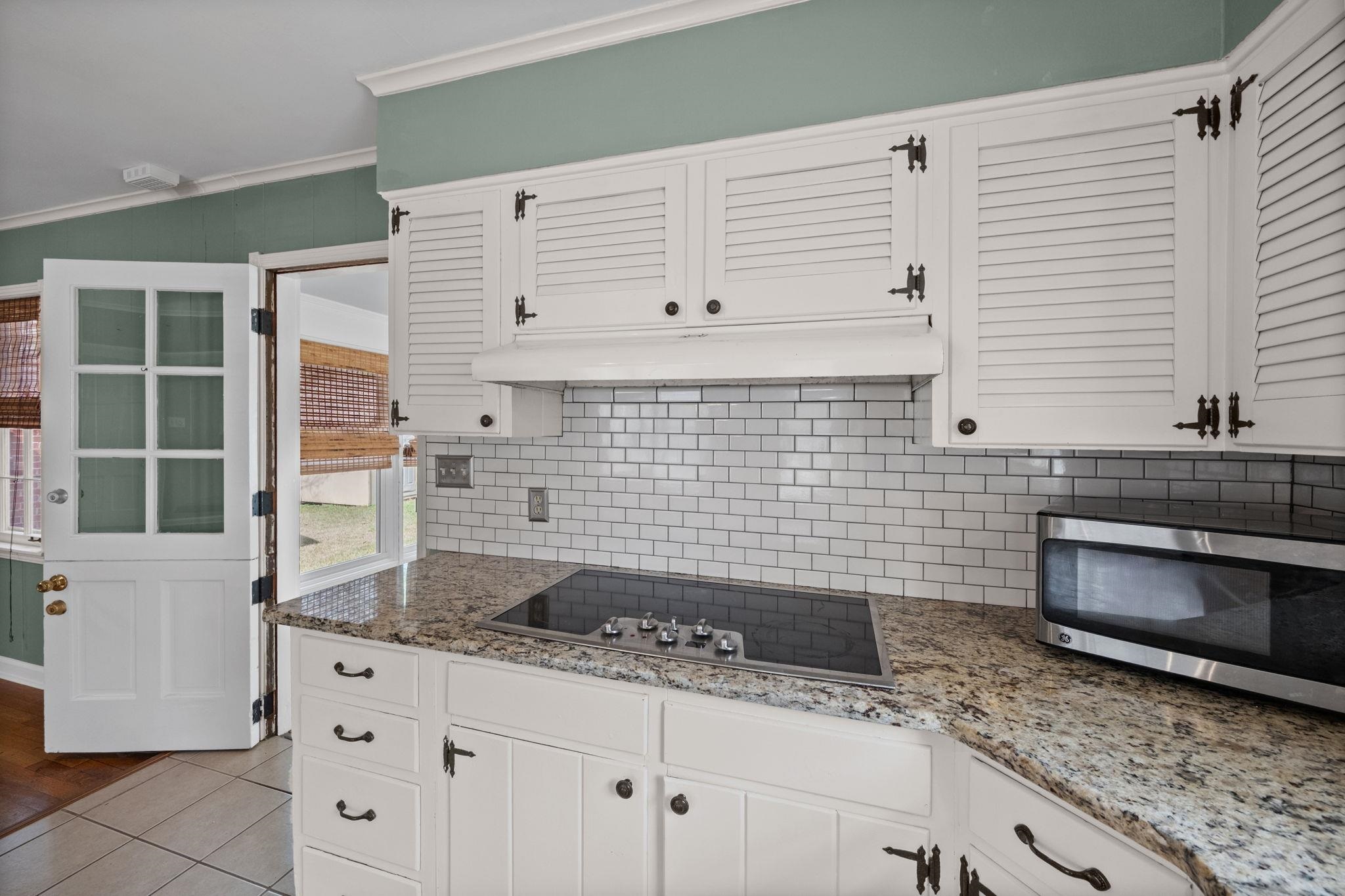 446 Rosser Road Memphis, TN 38120 - Photo 3 of 30 a kitchen with granite countertop white cabinets and white appliances
