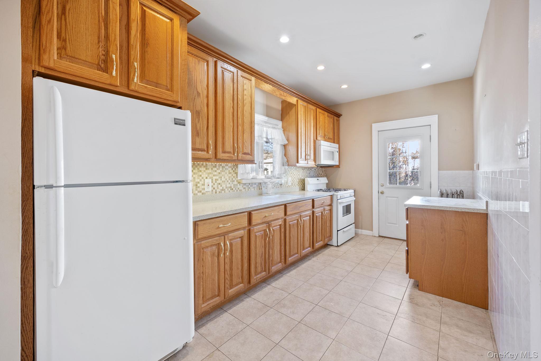 2109 Avenue R Brooklyn, NY 11229 - Photo 12 of 24 a kitchen with stainless steel appliances granite countertop a refrigerator a sink dishwasher a oven with white cabinets