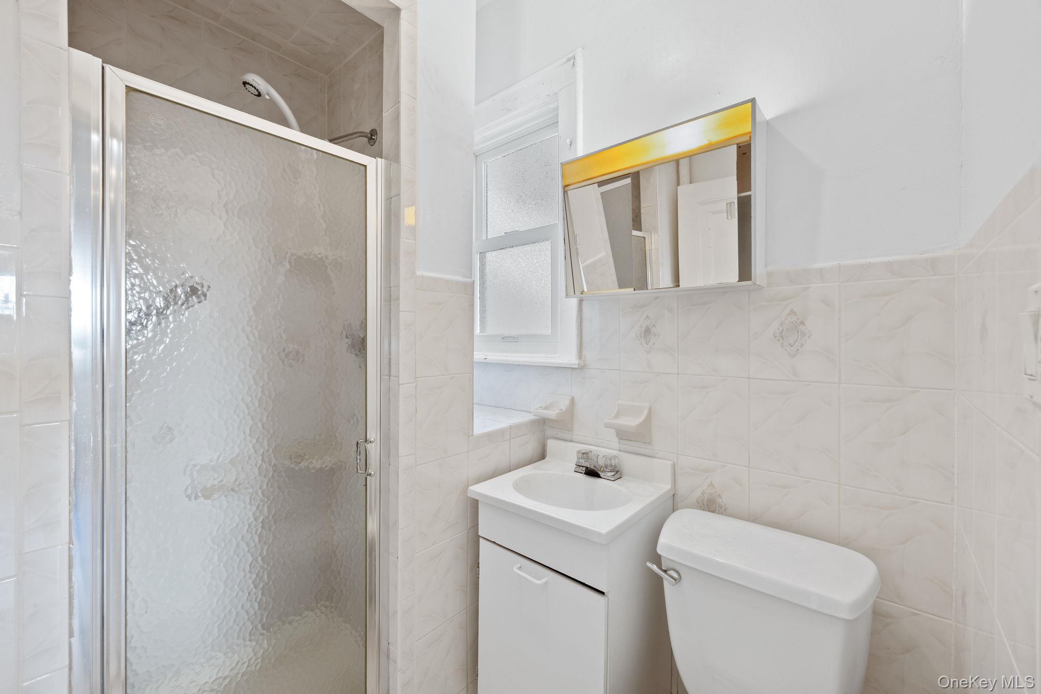 2109 Avenue R Brooklyn, NY 11229 - Photo 13 of 24 a bathroom with a toilet sink and mirror