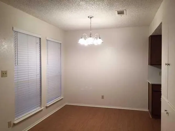 an empty room with chandelier fan