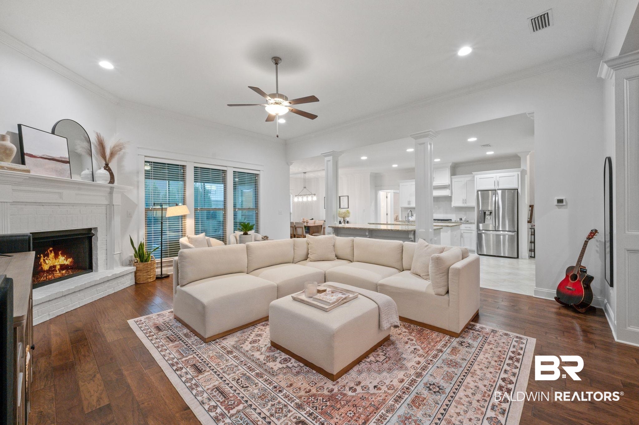418 Fortune Drive Fairhope, AL 36532 - Photo 5 of 63 Living room featuring a fireplace, hardwood / wood-style flooring, ceiling fan, ornamental molding, and ornate columns