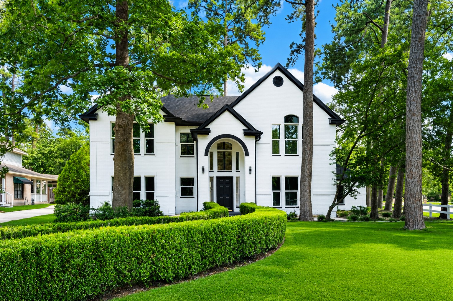 523 Rampart Lane Conroe, TX 77302 - Photo 2 of 41 Stunning curb appeal with a timeless painted brick exterior, grand entryway, mature pine trees, manicured landscaping, and an expansive front lawn in the prestigious River Plantation Golf Club community. Digitally enhanced.