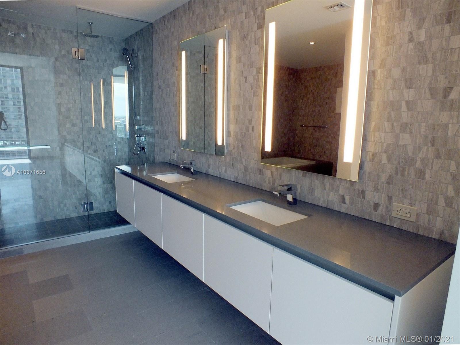 68 Southeast 6th Street, Unit 1010 Miami, FL 33131 - Photo 13 of 43 a bathroom with a sink and a large mirror