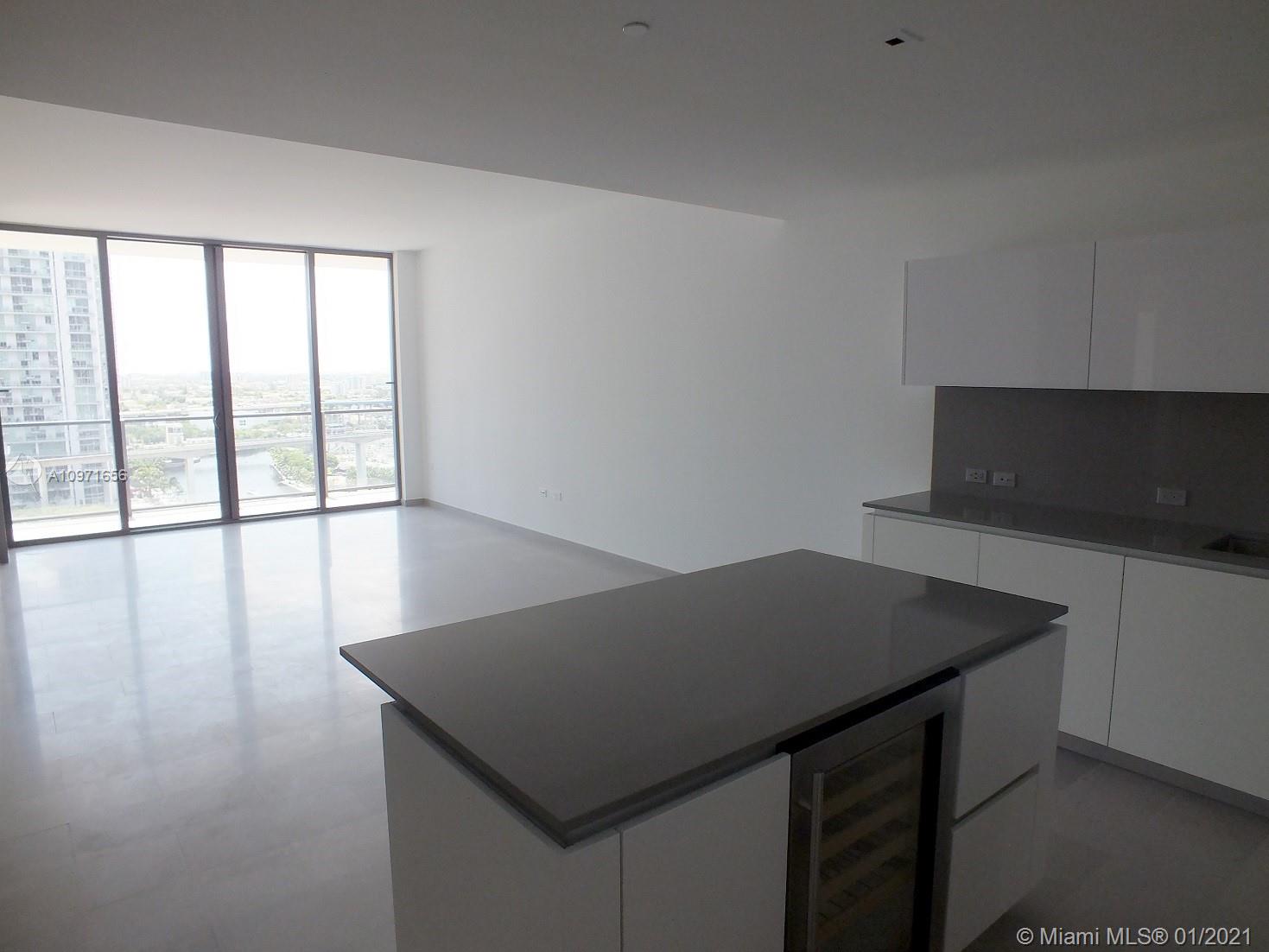 68 Southeast 6th Street, Unit 1010 Miami, FL 33131 - Photo 4 of 43 a kitchen with a table chairs and wooden floor