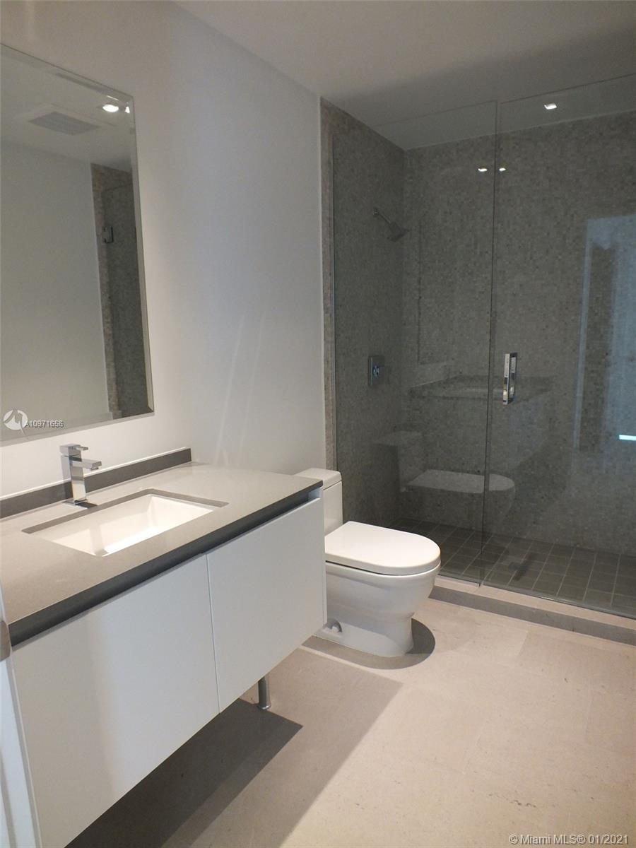 68 Southeast 6th Street, Unit 1010 Miami, FL 33131 - Photo 9 of 43 a bathroom with a toilet a sink and shower