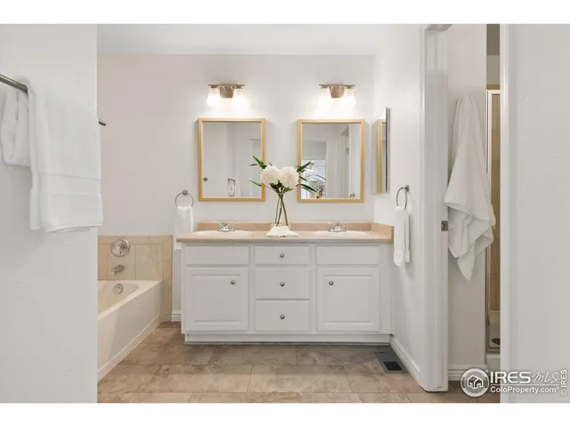 a bathroom with a granite countertop sink mirror and bathtub