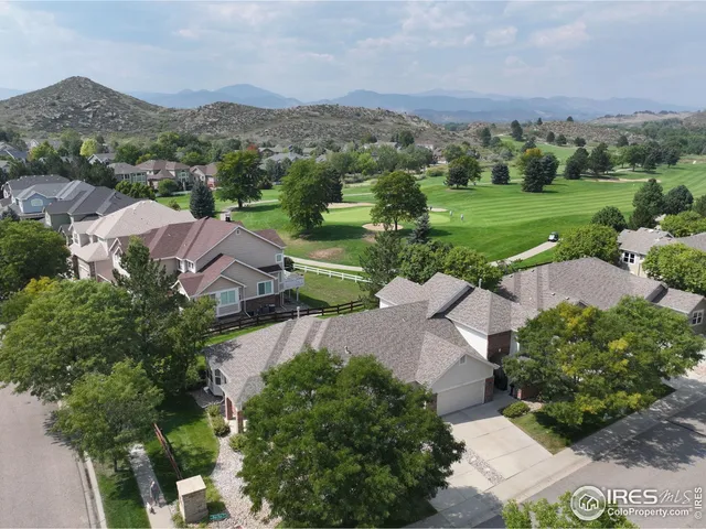 an aerial view of a houses with a yard and lake view
