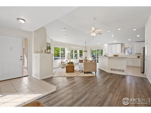 a living room with furniture and kitchen view with wooden floor