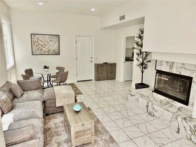 a kitchen with stainless steel appliances a sink a stove a refrigerator cabinets and a dining table