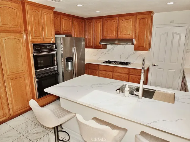 a kitchen with stainless steel appliances a stove a sink a microwave and cabinets